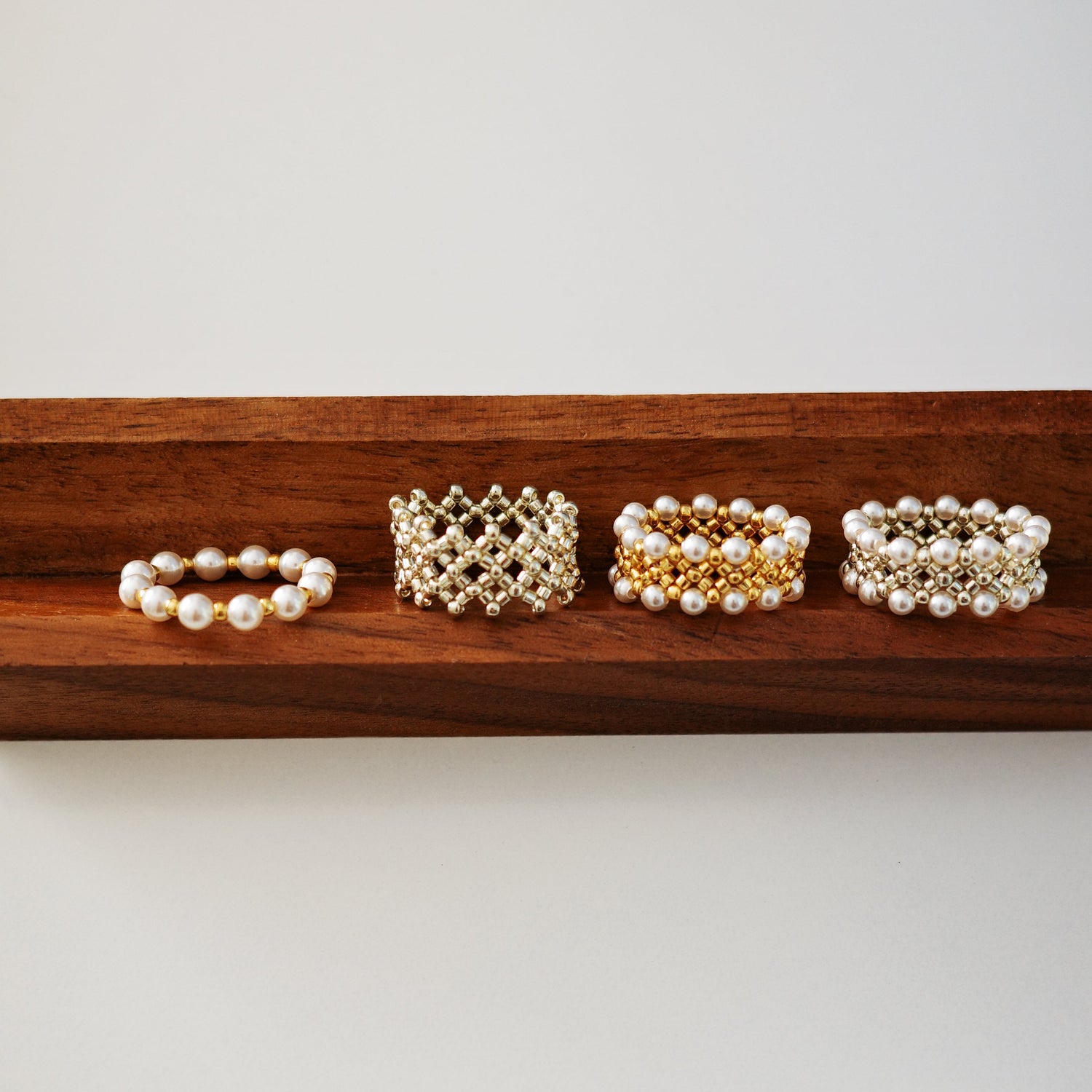 Set of beaded rings on a wooden tray against a light background